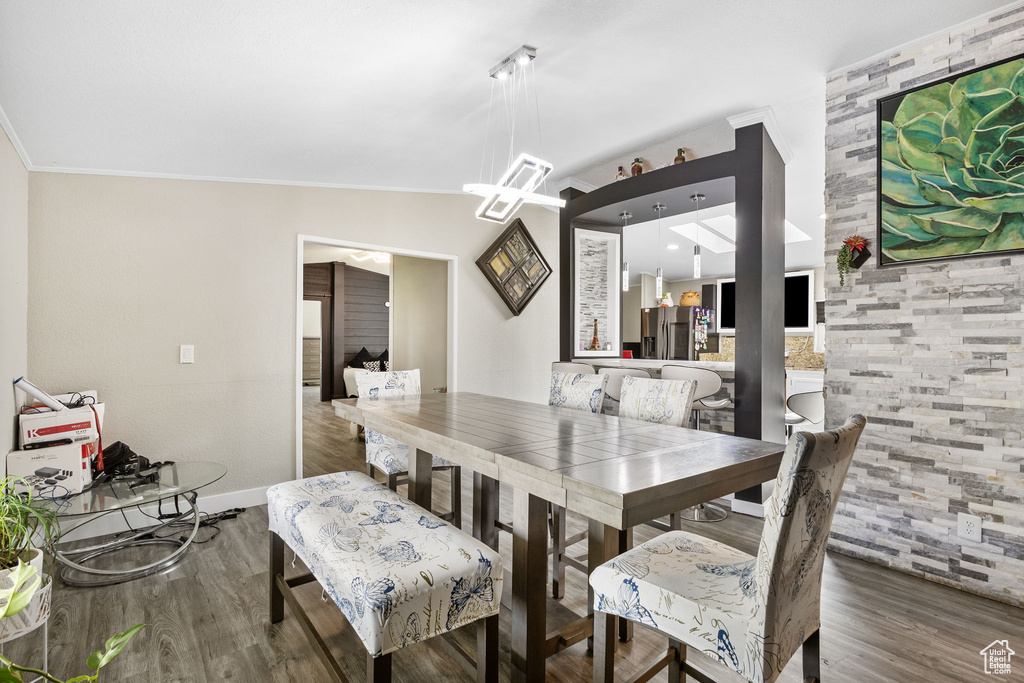 Dining space with baseboards, ornamental molding, and wood finished floors