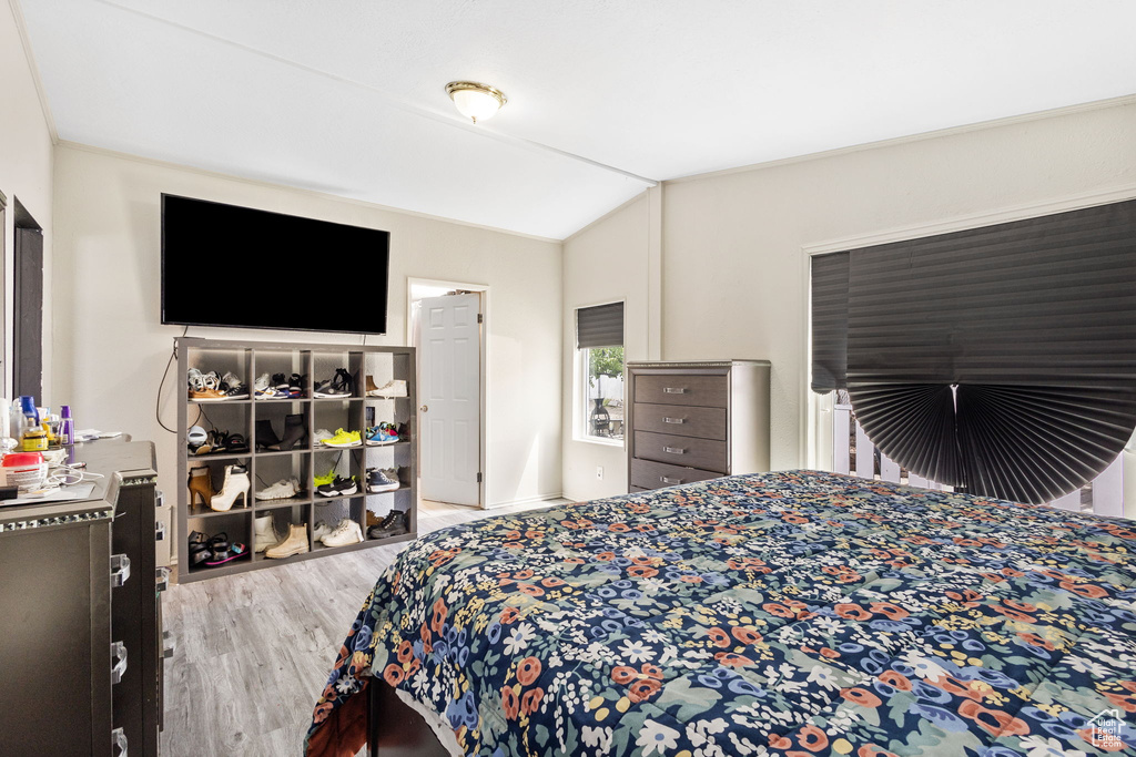 Bedroom with wood finished floors and lofted ceiling
