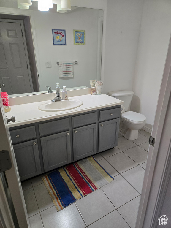 Half bath with toilet, vanity, and tile patterned flooring