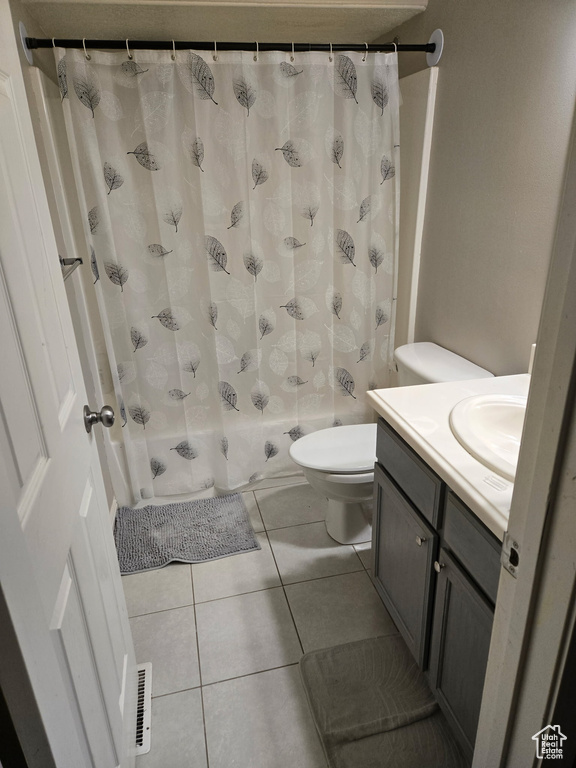 Bathroom featuring toilet, tile patterned flooring, visible vents, and vanity