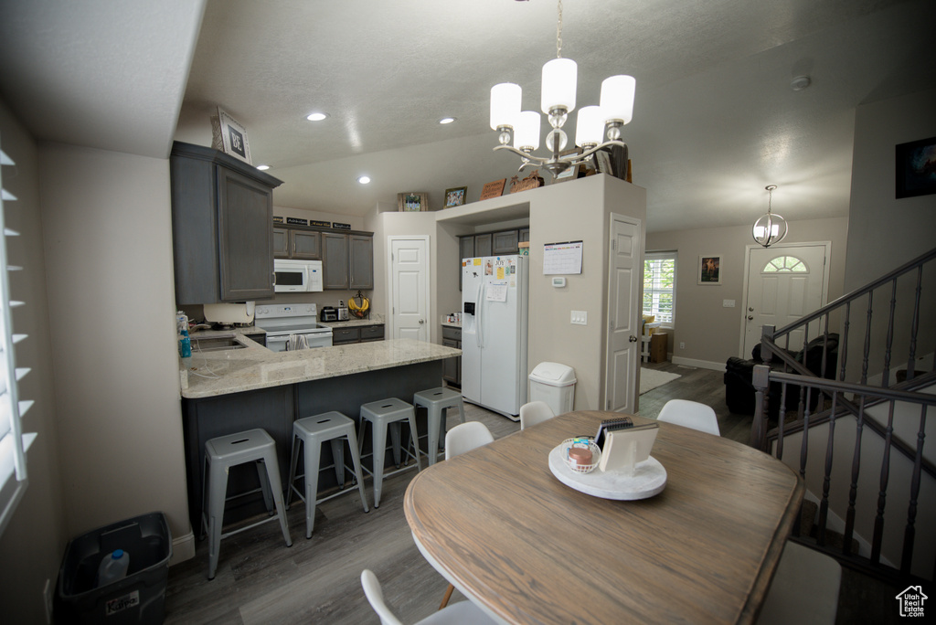 Dining area featuring light wood-type flooring, stairway, baseboards, a notable chandelier, and recessed lighting