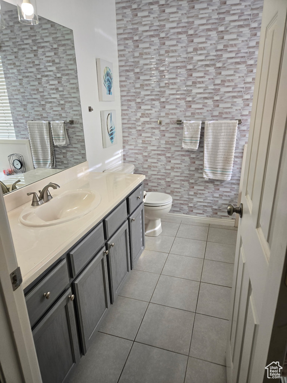 Bathroom with toilet, tile patterned flooring, and vanity