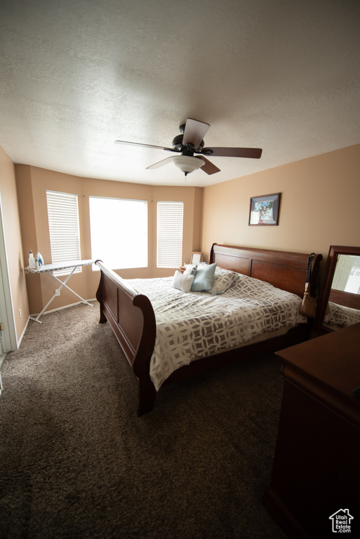 Bedroom with baseboards, ceiling fan, and carpet