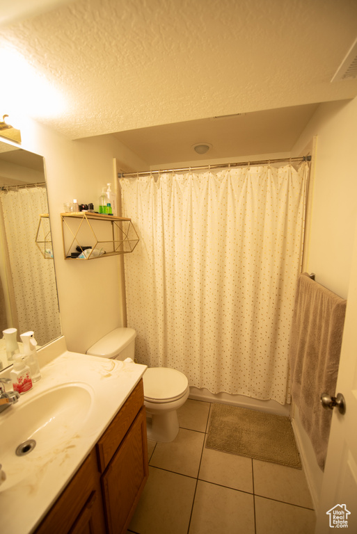 Full bath featuring tile patterned floors, vanity, toilet, and a shower with shower curtain