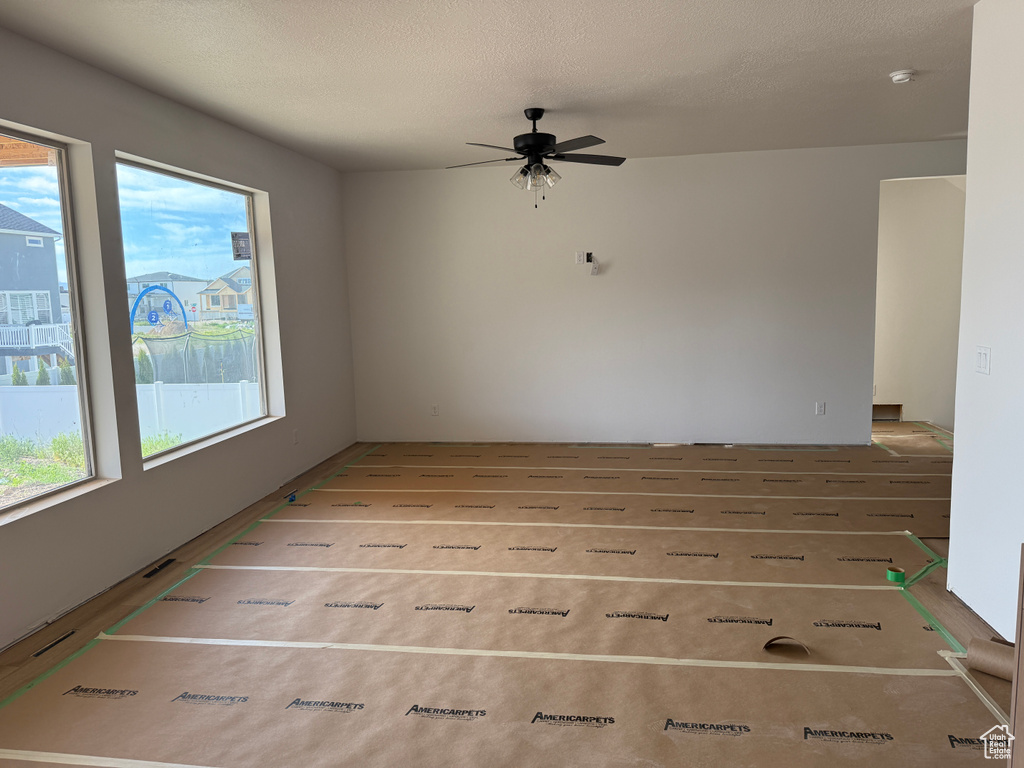 Unfurnished room featuring ceiling fan and a smoke detector