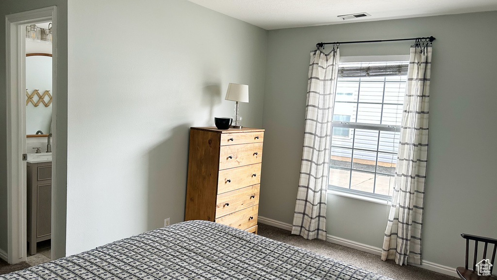 Carpeted bedroom featuring visible vents and baseboards