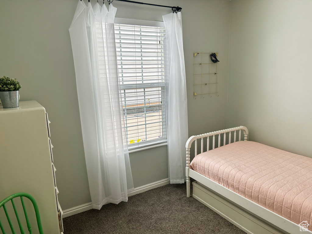 Bedroom featuring baseboards and dark colored carpet