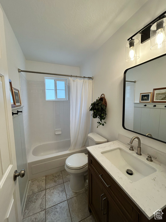 Full bathroom with shower / bath combo, toilet, a textured ceiling, and vanity