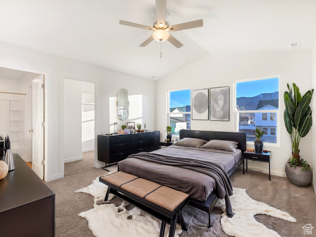 Bedroom featuring a ceiling fan, visible vents, light carpet, baseboards, and lofted ceiling
