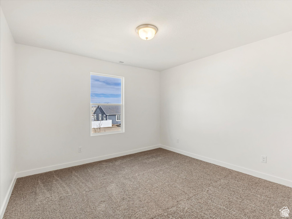 Spare room with baseboards and carpet flooring