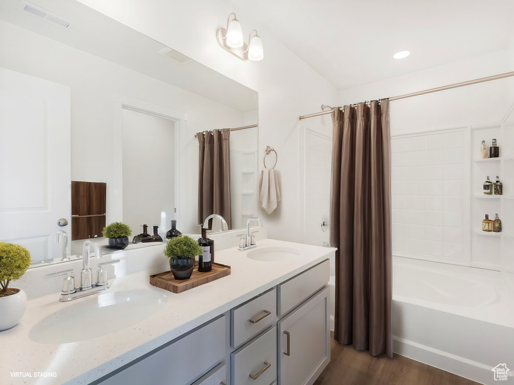 Full bath with visible vents, shower / bath combination with curtain, double vanity, and a sink