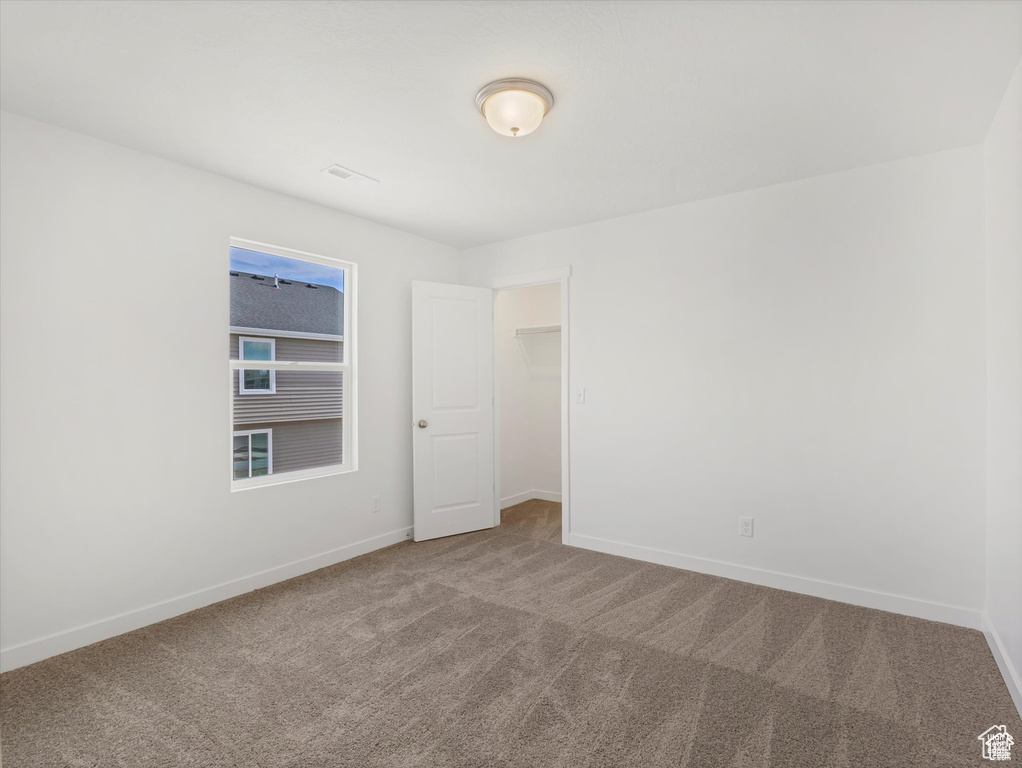 Carpeted empty room with baseboards