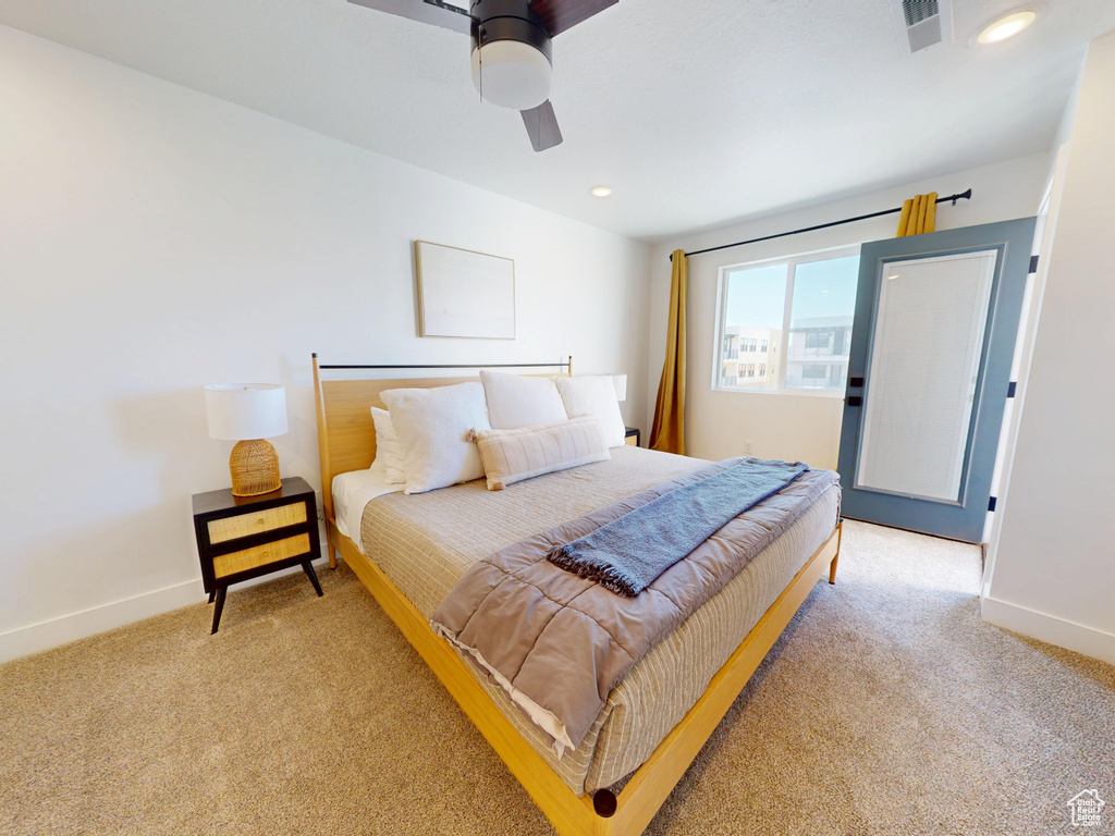 Bedroom featuring a ceiling fan, visible vents, light colored carpet, and baseboards
