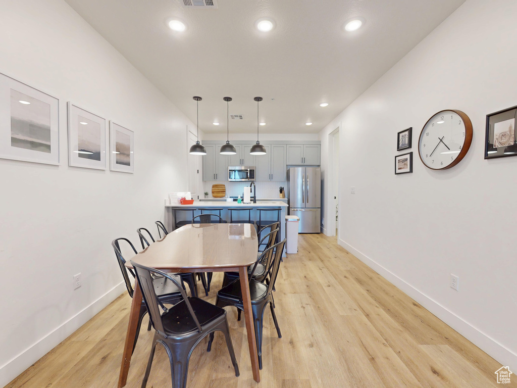 Dining room with recessed lighting, visible vents, light wood-style floors, and baseboards