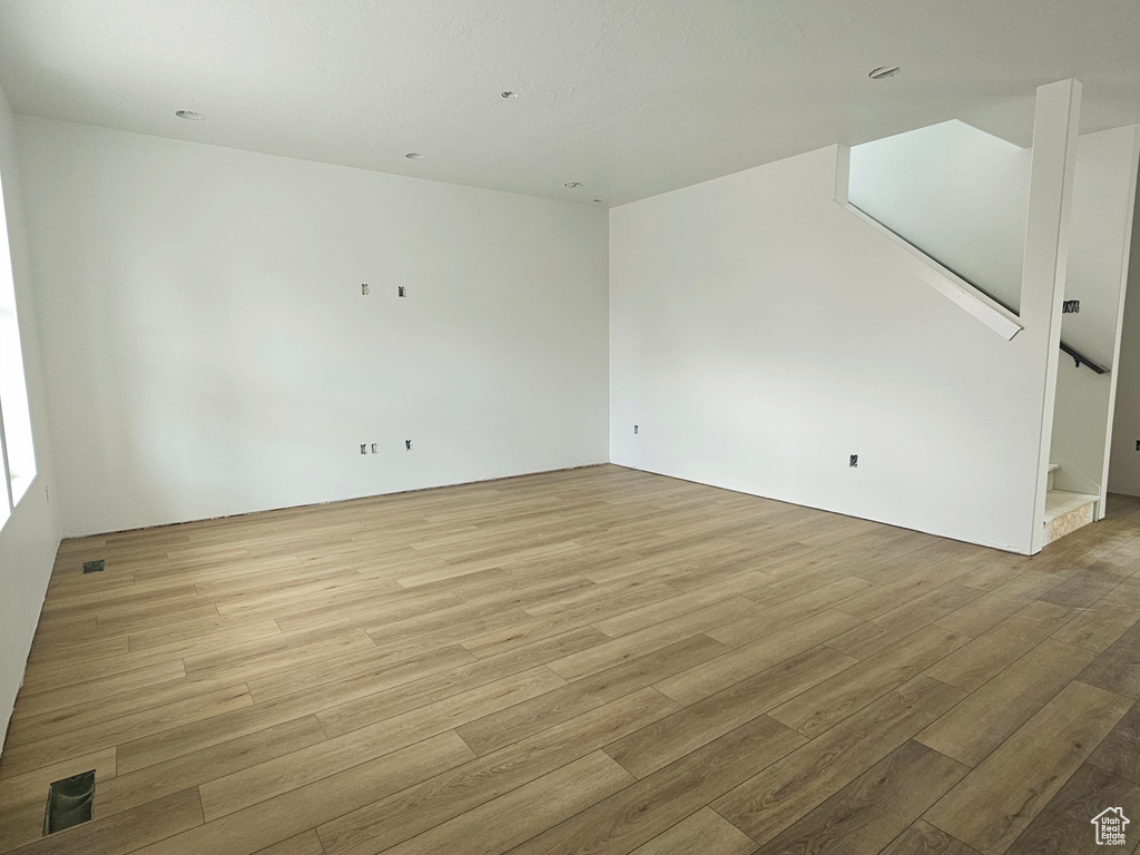 Unfurnished room with light wood-style flooring and stairs