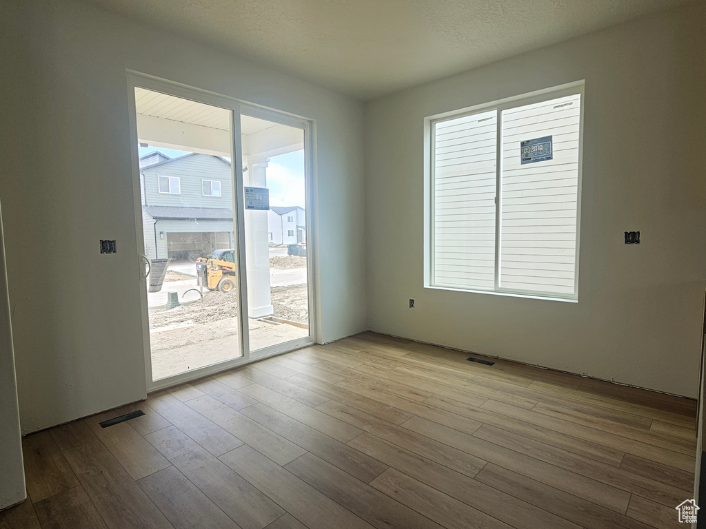 Empty room featuring visible vents and wood finished floors