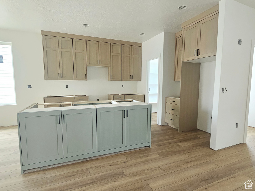 Kitchen with light wood finished floors and a kitchen island