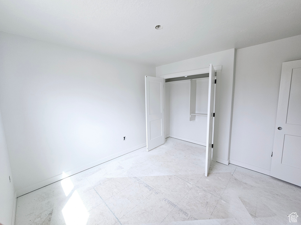 Unfurnished bedroom featuring a closet and baseboards