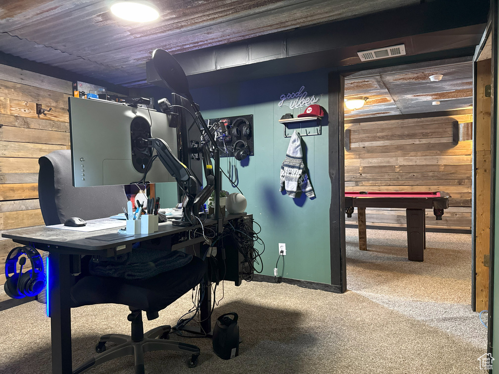 Carpeted office space with wooden walls and baseboards