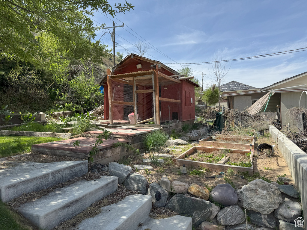 View of yard featuring an outbuilding, a garden, and fence