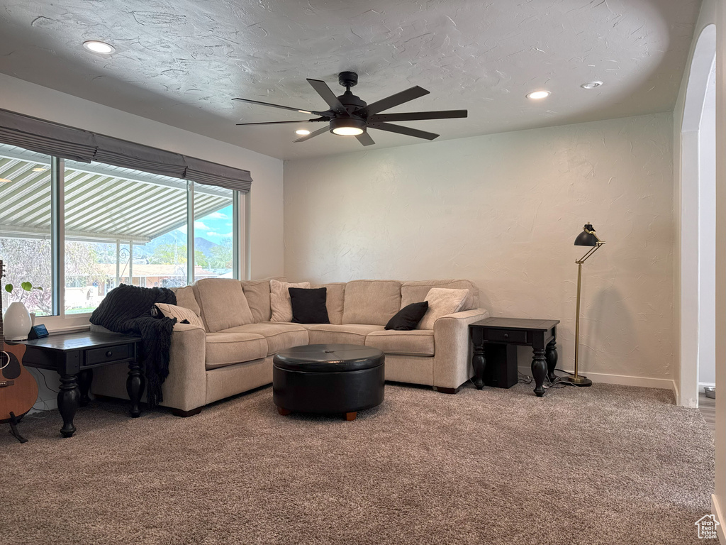 Carpeted living area with baseboards, recessed lighting, and a ceiling fan