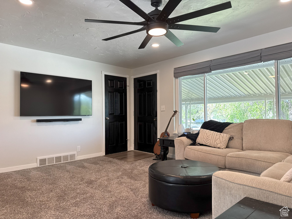 Carpeted living area featuring recessed lighting, visible vents, ceiling fan, and baseboards