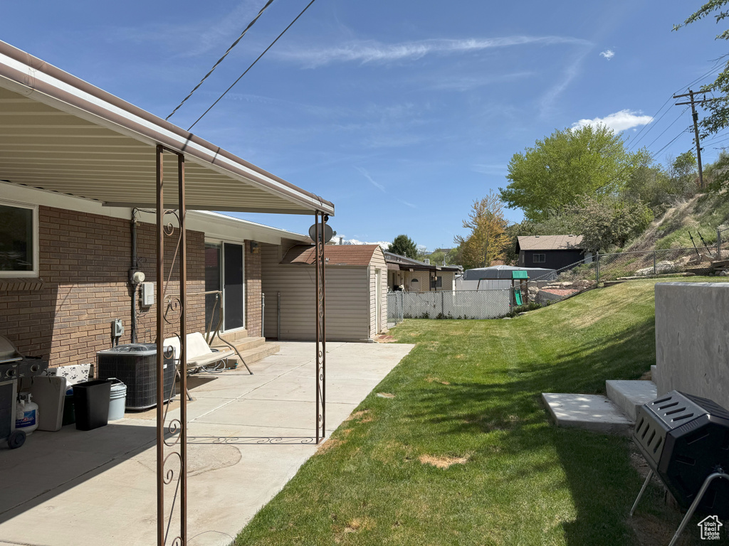 View of yard featuring fence, entry steps, central air condition unit, and a patio area