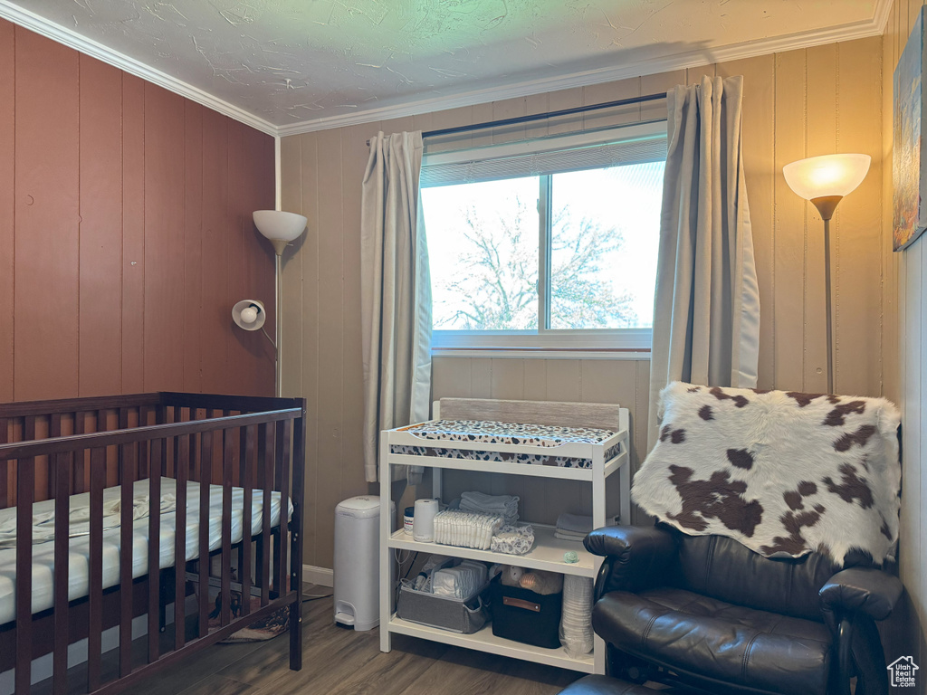 Bedroom with crown molding and wood finished floors