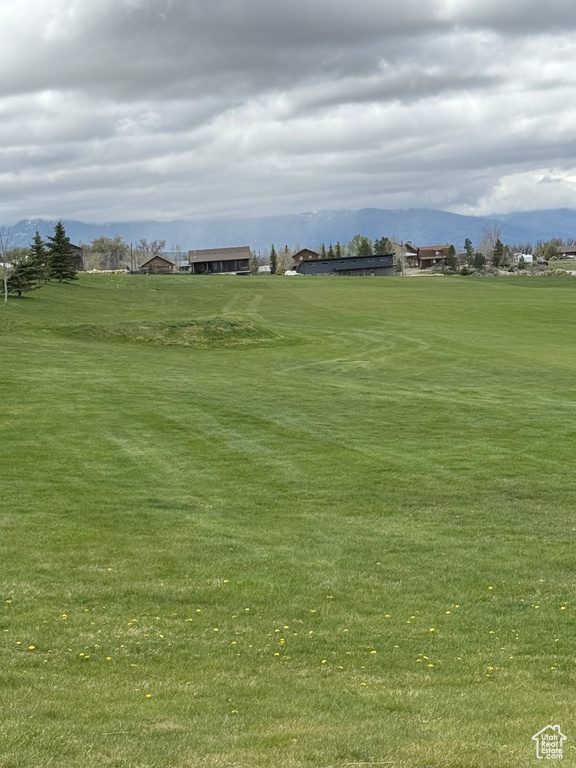 Surrounding community featuring a mountain view and a lawn