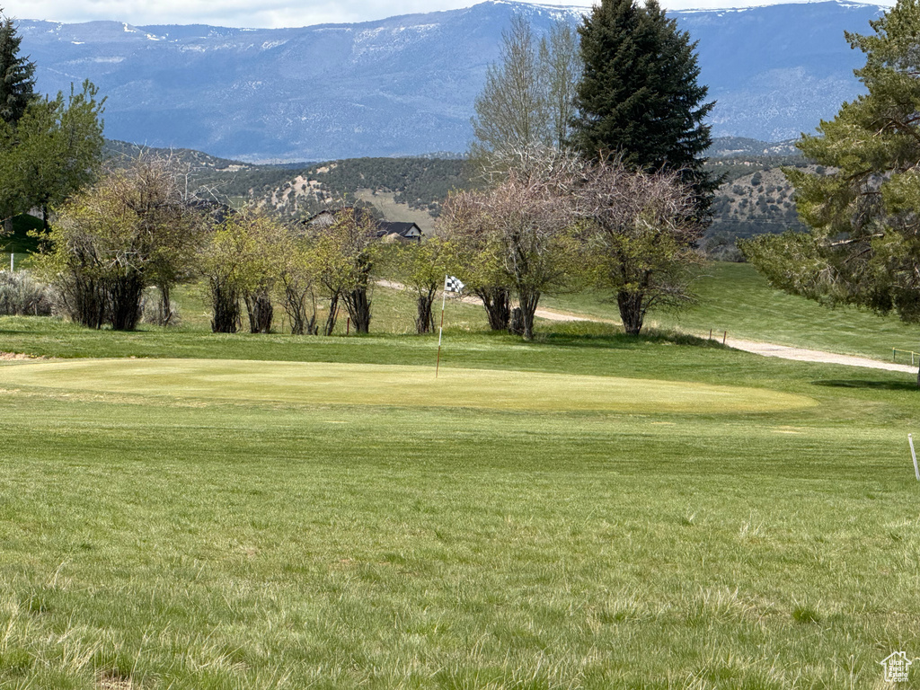 View of home\\\\\\\'s community featuring a lawn, golf course view, and a mountain view