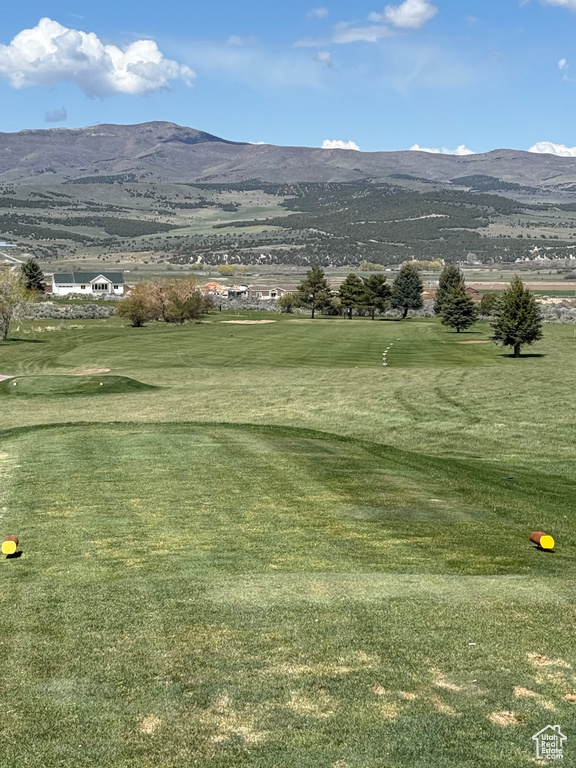 Surrounding community with a lawn, a mountain view, and view of golf course