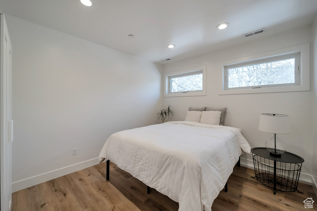 Bedroom with recessed lighting, visible vents, wood finished floors, and baseboards