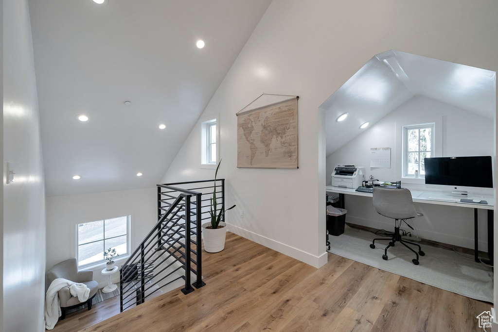 Office space featuring wood finished floors, a wealth of natural light, and vaulted ceiling