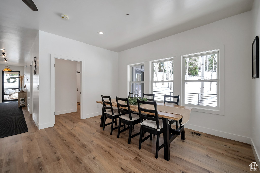 Dining area featuring light wood-type flooring, visible vents, and a wealth of natural light