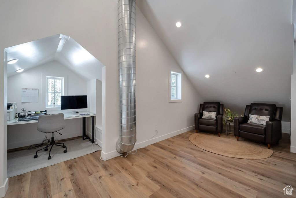 Office with light wood-style flooring, vaulted ceiling, and a wealth of natural light
