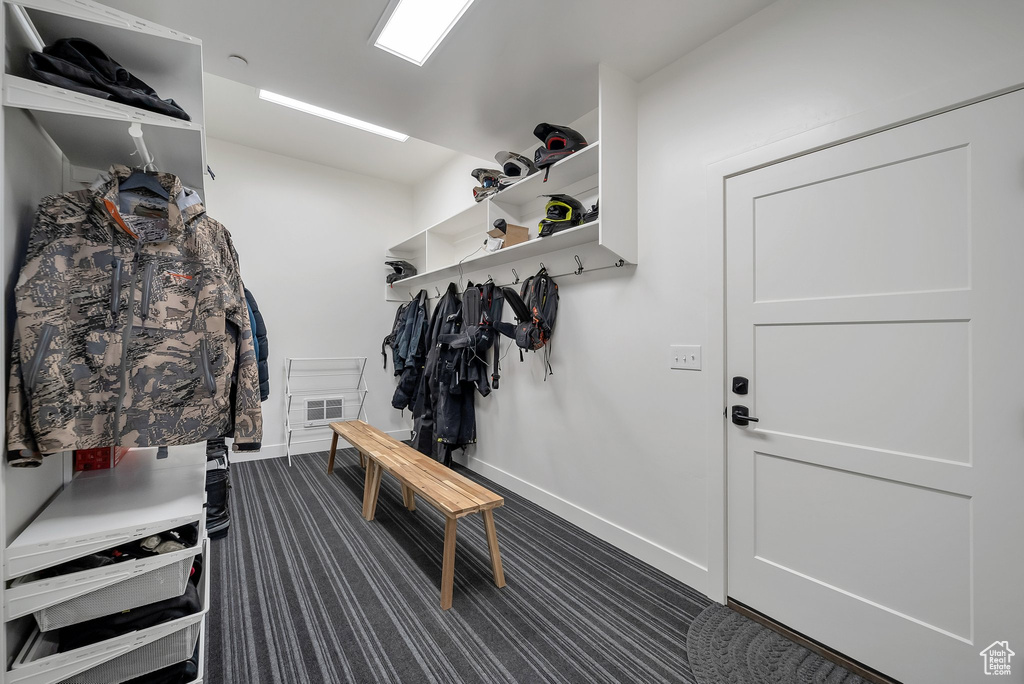 Mudroom featuring visible vents, dark carpet, and baseboards