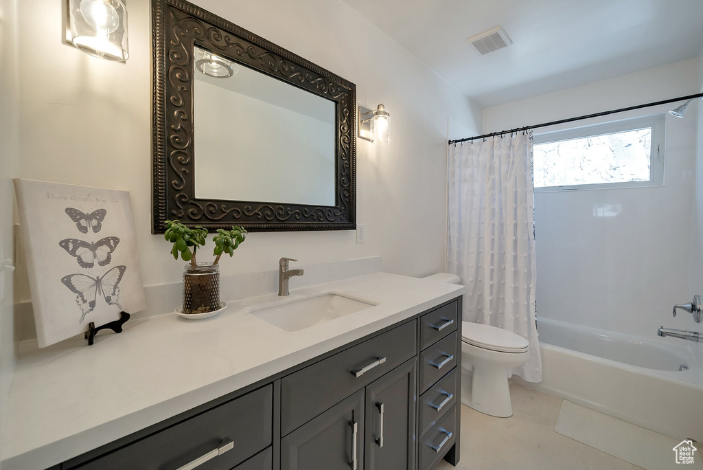 Bathroom with toilet, visible vents, shower / bath combo with shower curtain, and vanity