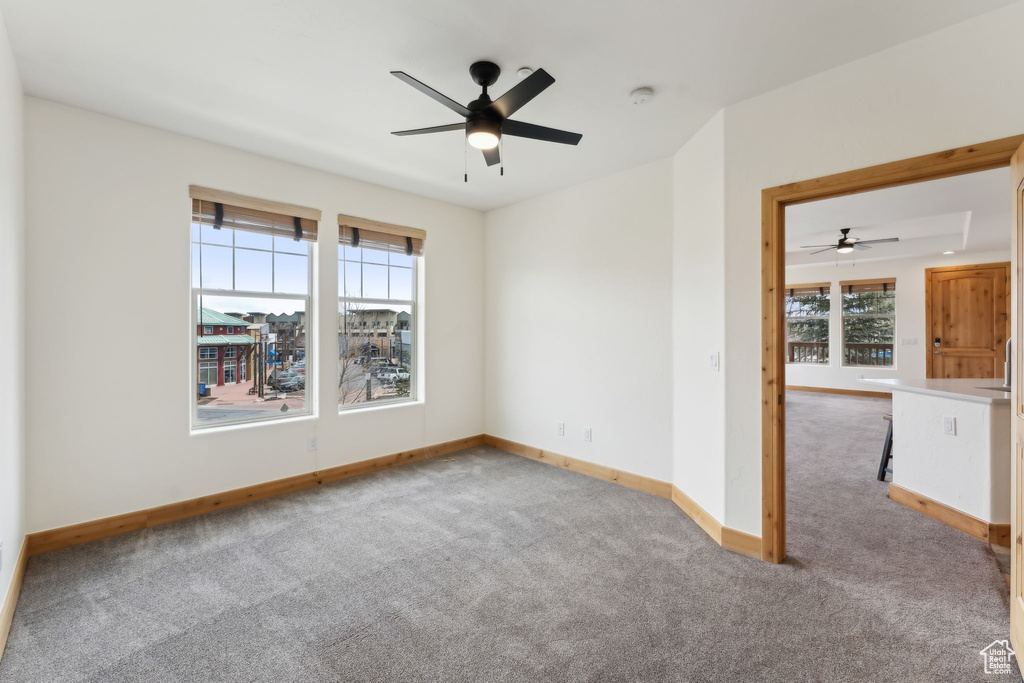 Spare room with ceiling fan, baseboards, and carpet floors