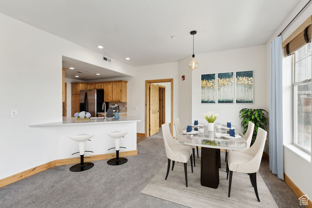 Dining area featuring baseboards, light carpet, recessed lighting, and visible vents
