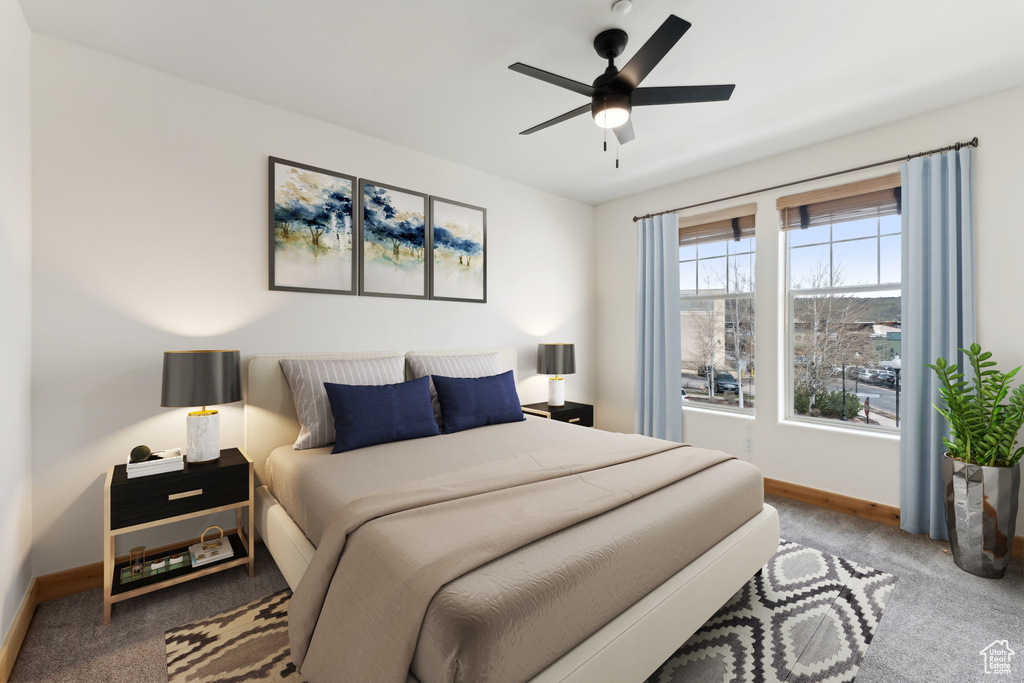 Carpeted bedroom featuring a ceiling fan and baseboards
