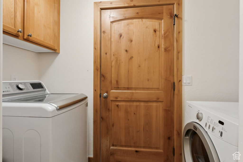 Washroom with cabinet space and washer and clothes dryer