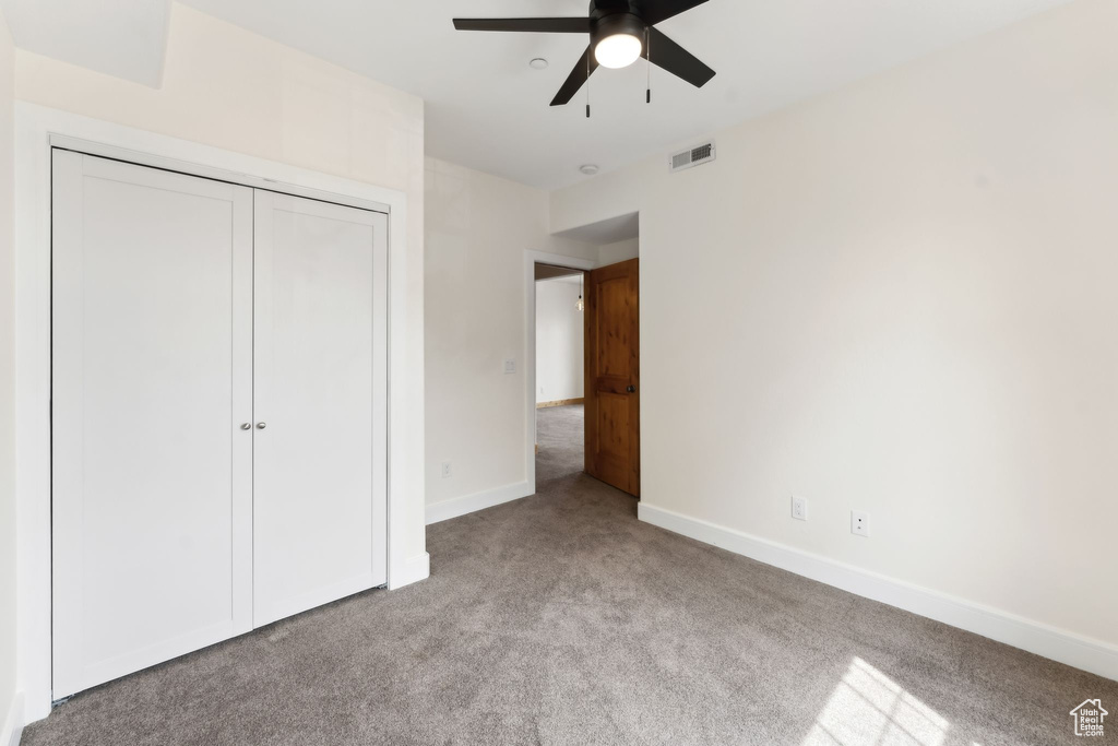 Unfurnished bedroom with visible vents, ceiling fan, a closet, baseboards, and carpet
