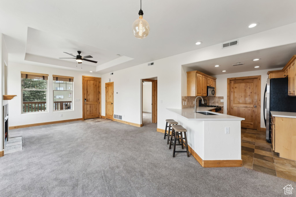 Kitchen featuring visible vents, light countertops, a ceiling fan, and a sink
