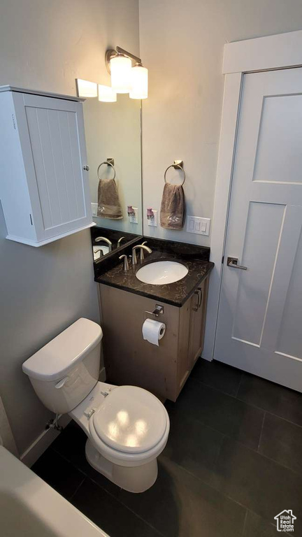 Bathroom featuring vanity, tile patterned floors, and toilet