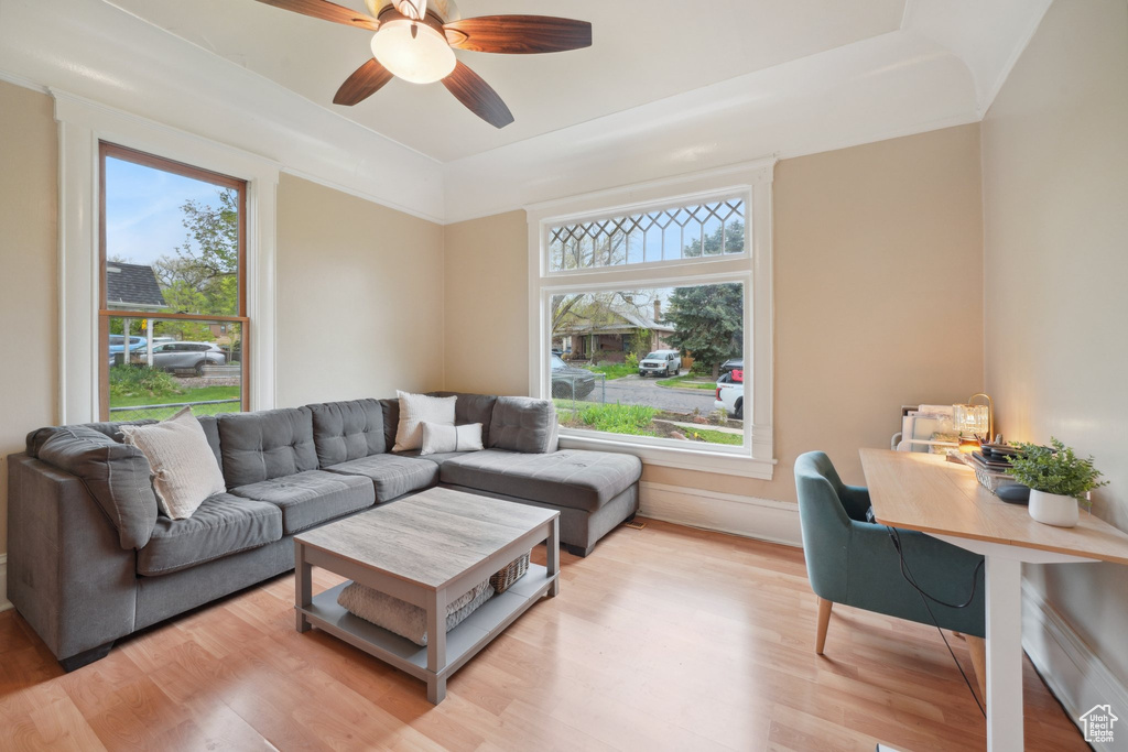 Living area with a ceiling fan, light wood-style floors, and plenty of natural light
