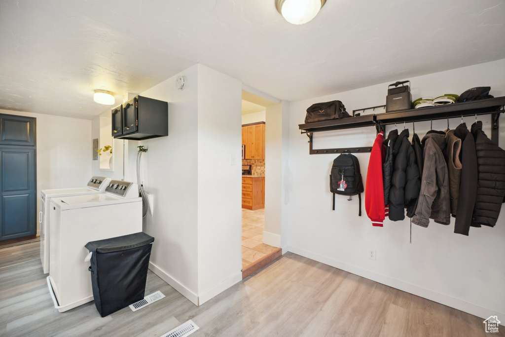 Laundry room featuring visible vents, baseboards, light wood finished floors, and washing machine and dryer