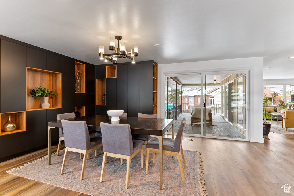 Dining space with light wood-style flooring and a notable chandelier
