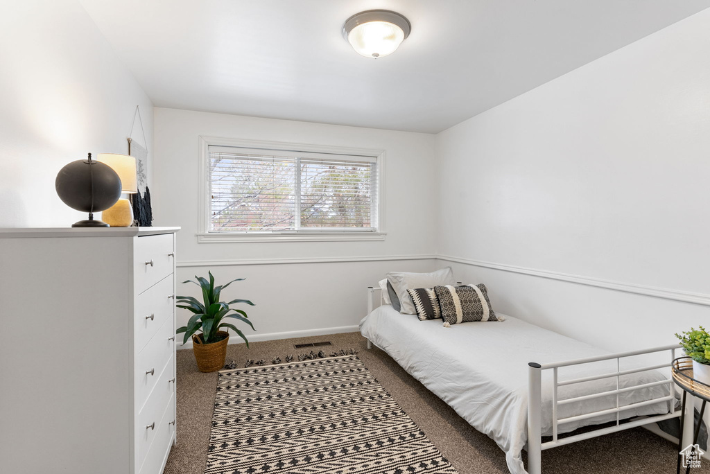 Carpeted bedroom featuring baseboards and visible vents