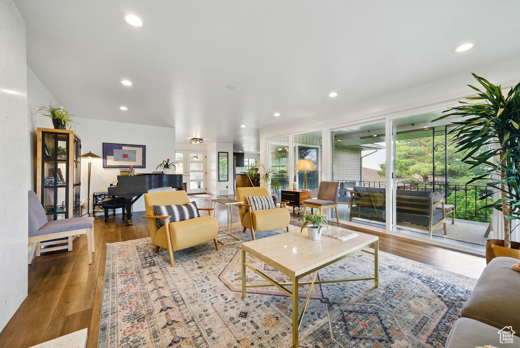 Living area with recessed lighting, a healthy amount of sunlight, and wood finished floors