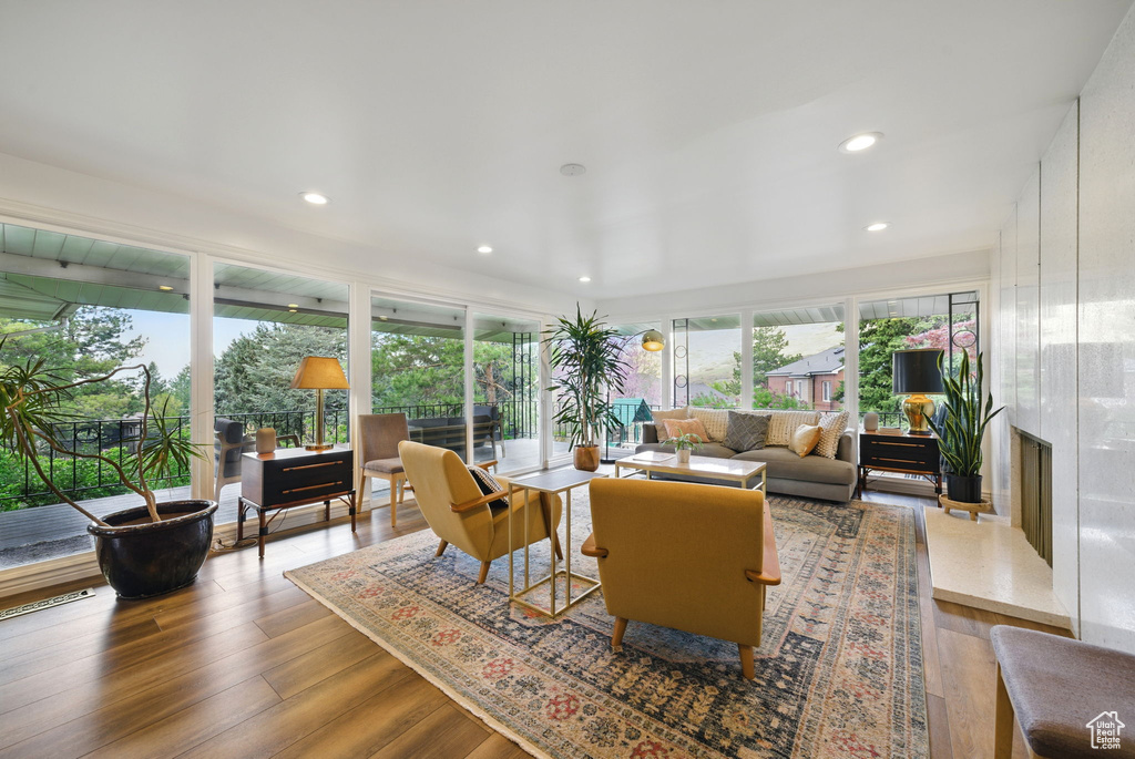 Living area featuring a premium fireplace, recessed lighting, and wood finished floors